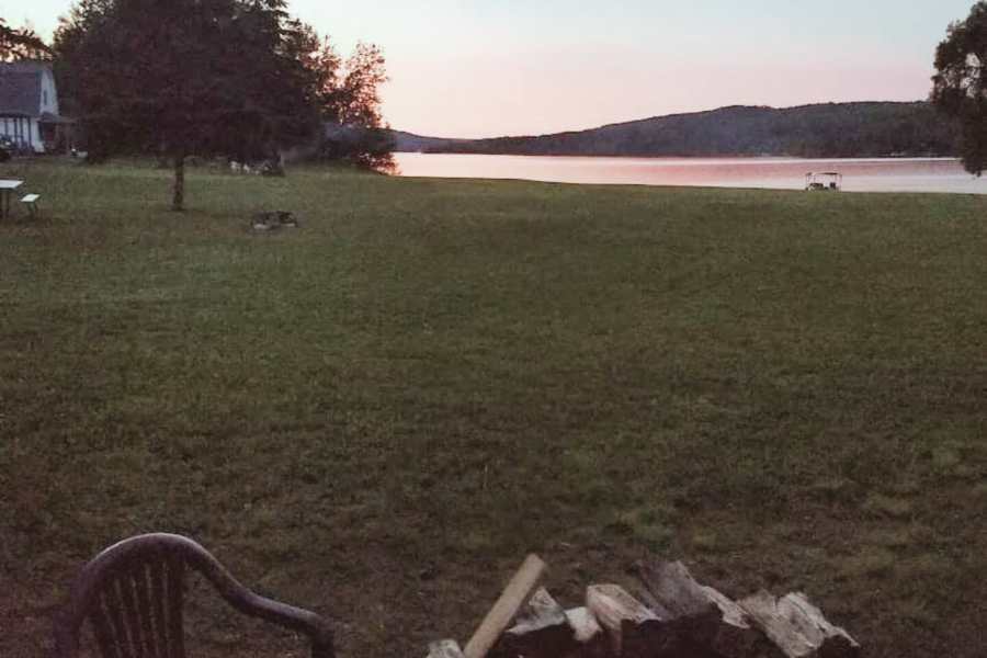 The fire pit at Eagles Landing at sunset, with open lawn running down to Eagle Lake.