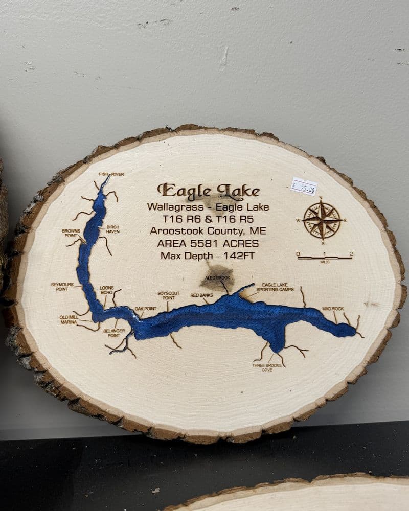 A wood-burned map of Eagle Lake on a round slab, labeled Wallagrass - Eagle Lake, Aroostook County, 5,581 acres, max depth 142 feet.